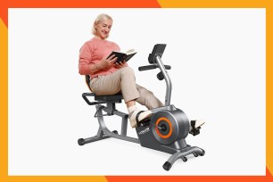 A woman reading a book while exercising on stationary bike