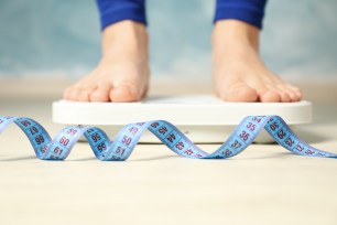  Woman stands on the scales. Measuring tape. Weight loss